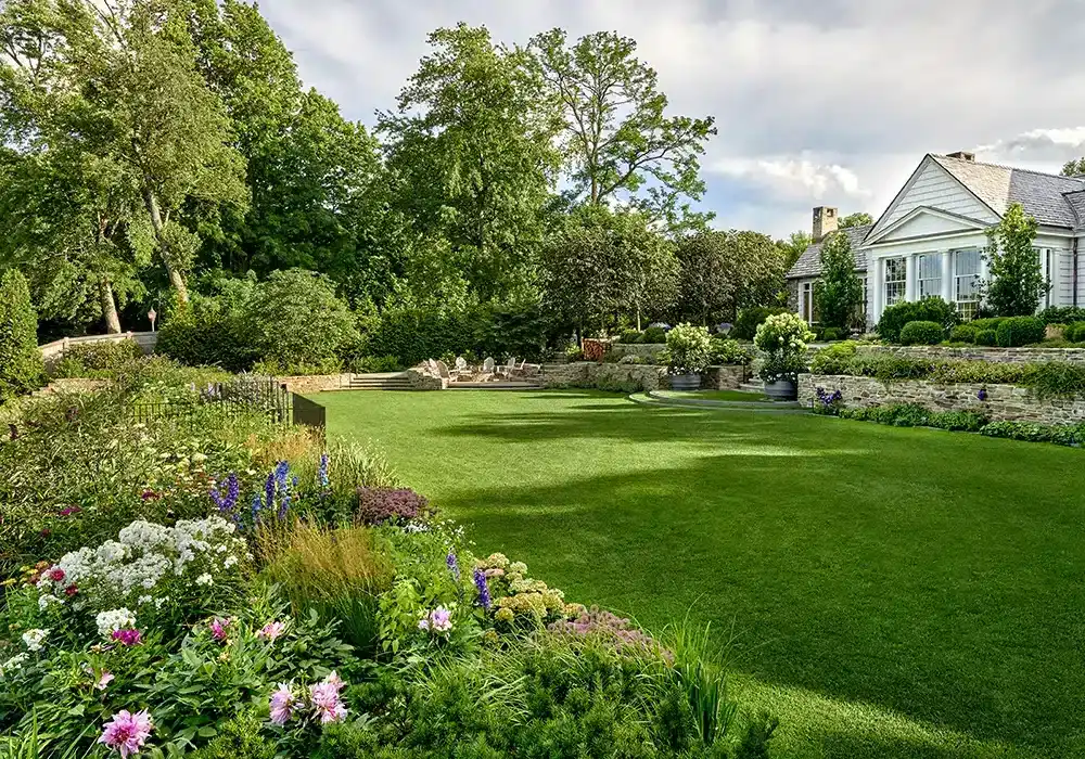 A home with a large lawn and flowers.