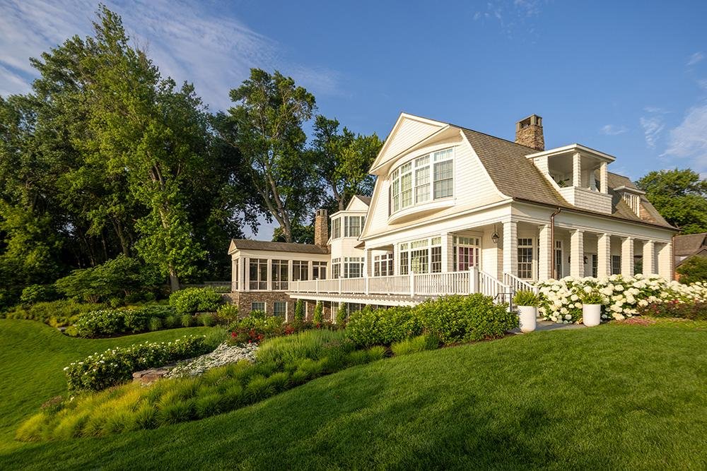 A large white house on a green lawn.