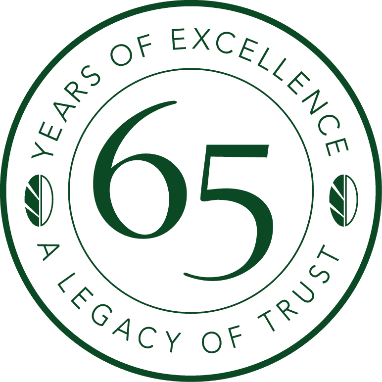 Circular logo with the number 65 in the center. Text around edge reads, "Years of Excellence" and "A Legacy of Trust" with leaf designs on sides.
